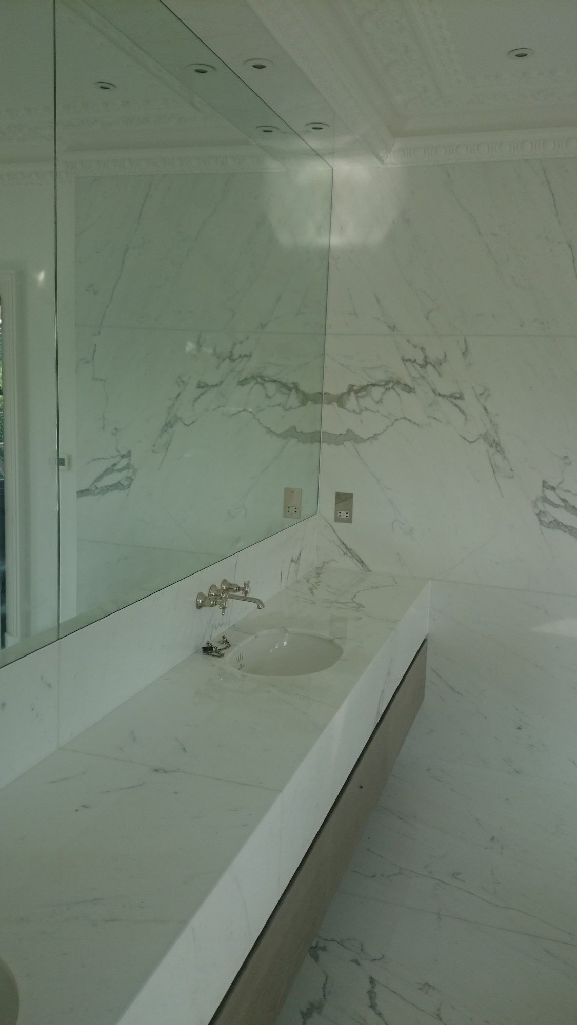 Book-matched marble vanity wall with a floating basin unit