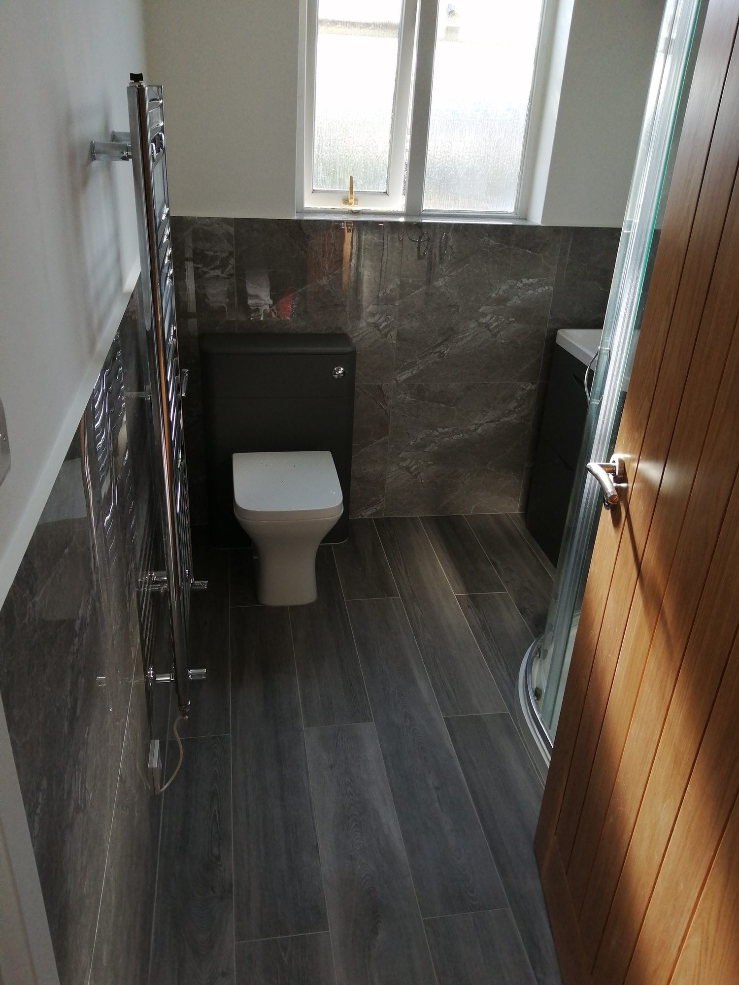 Bathroom with marble-effect tiles and wood-effect floor, Brent
